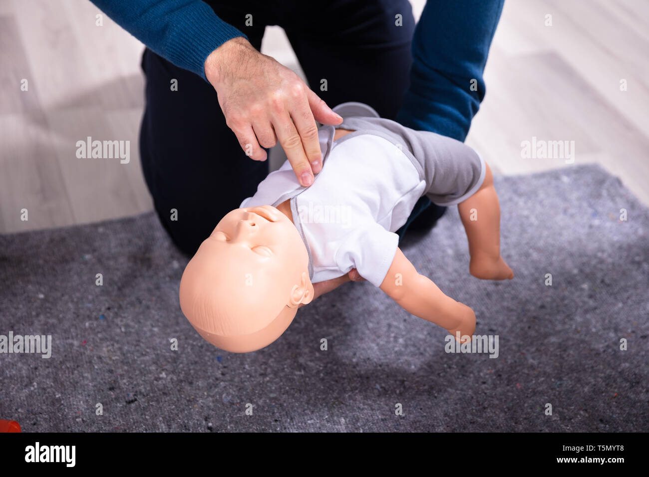 Specialist Giving Baby CPR Dummy First Aid Training To His Colleagues Stock Photo