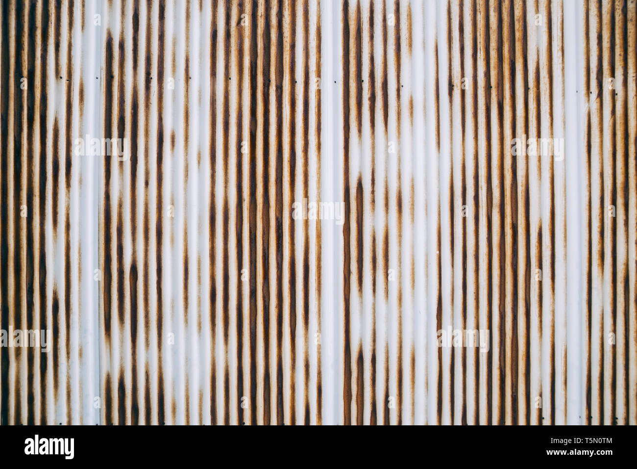 Old rusty wavy metal plate wall background Stock Photo