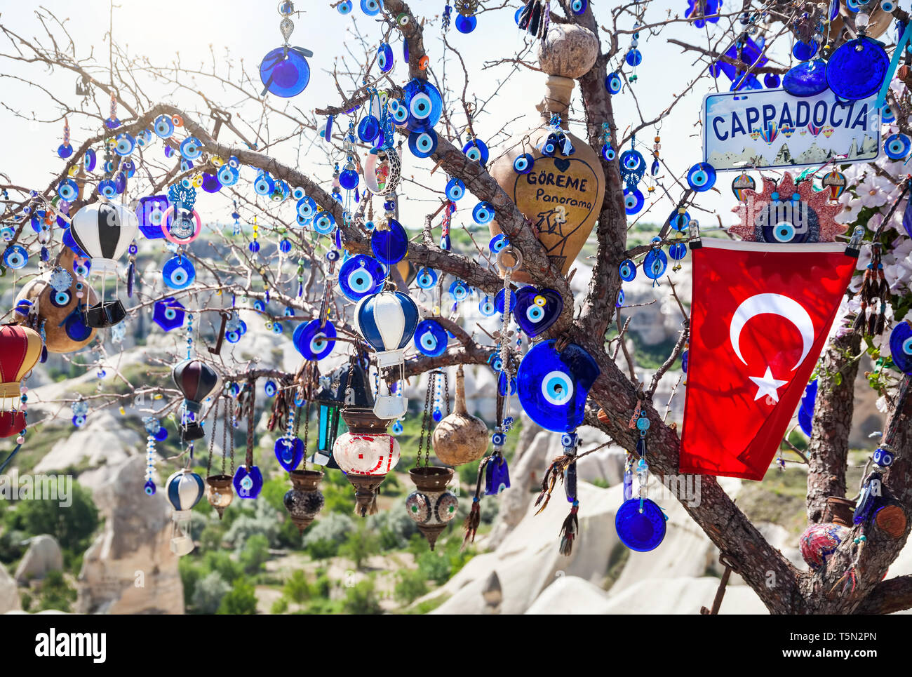 Evil eyes, balloon and Turkish flag on the tree in Goreme panorama Cappadocia, Turkey Stock Photo