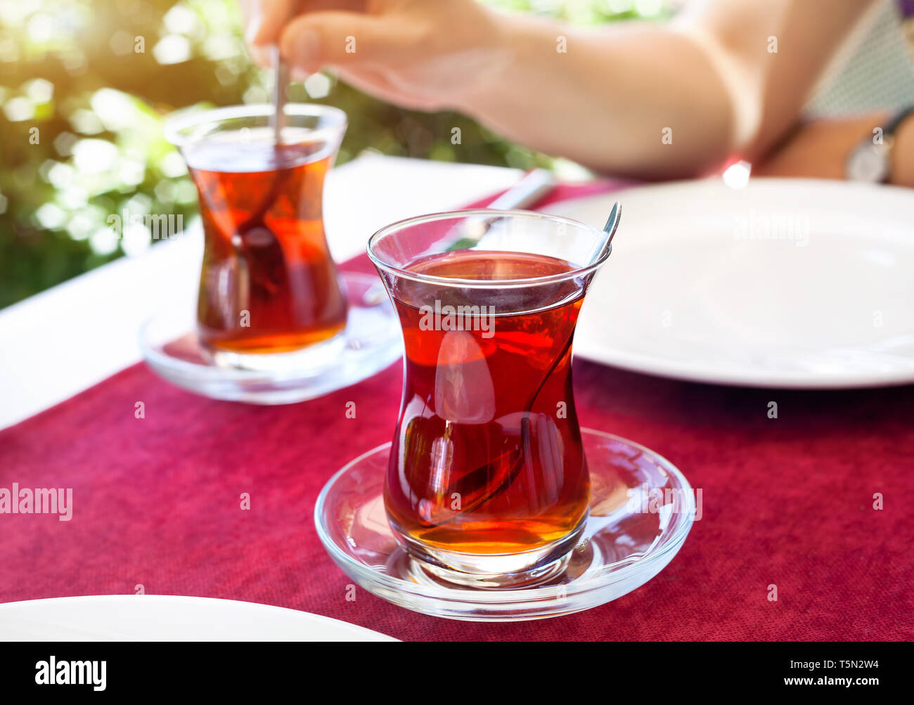 Turkish tea in restaurant in traditional glass on the red table in Turkey Stock Photo