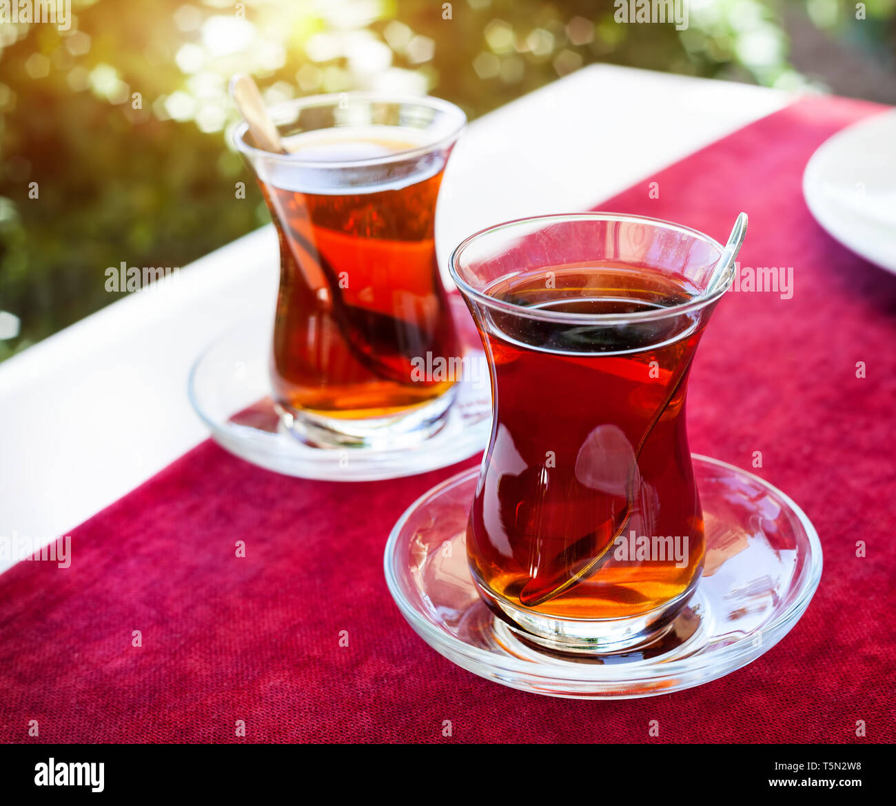 Turkish tea in restaurant in traditional glass on the red table in Turkey Stock Photo