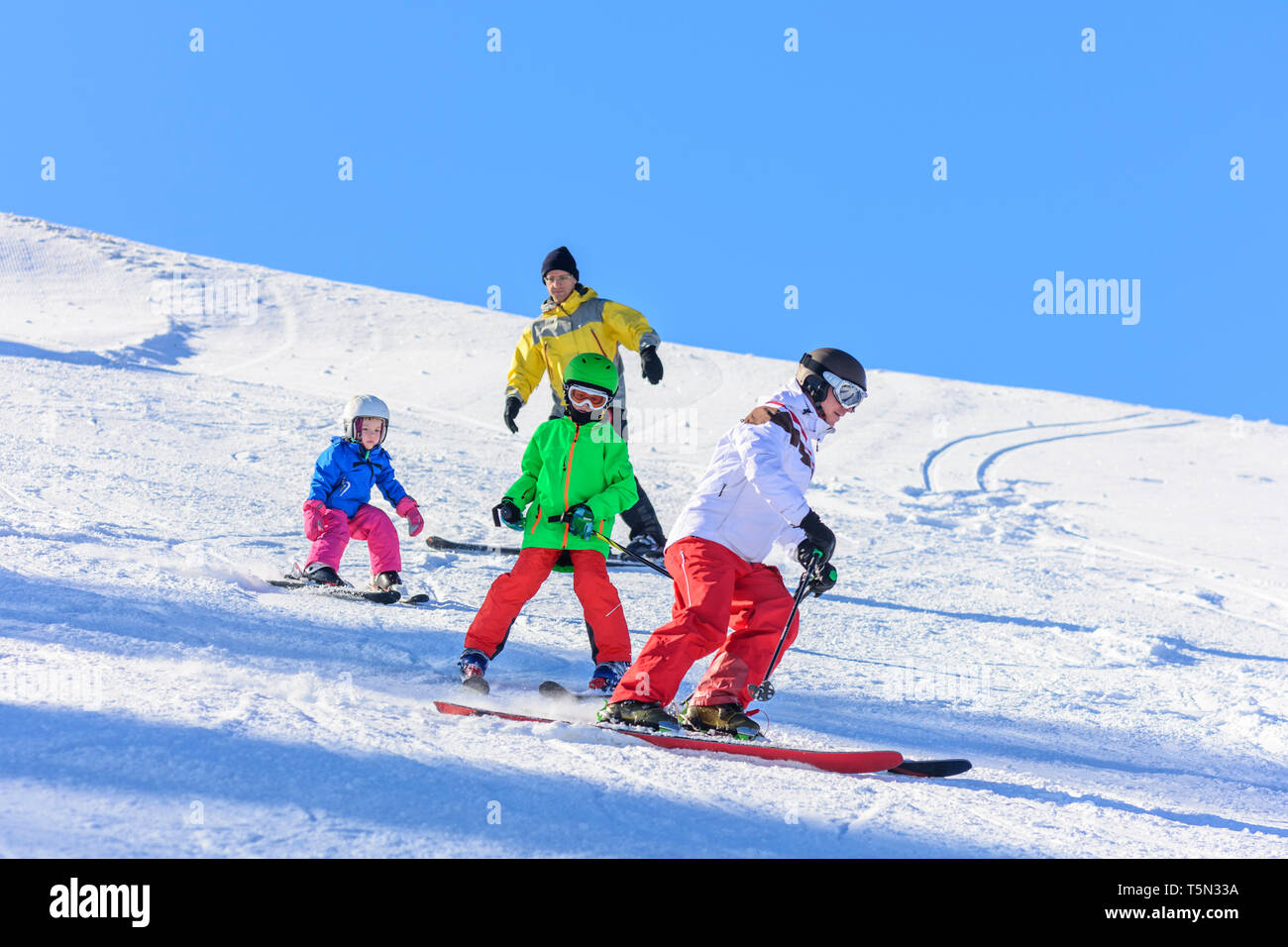 Skiing with the kids on sunny winter day Stock Photo
