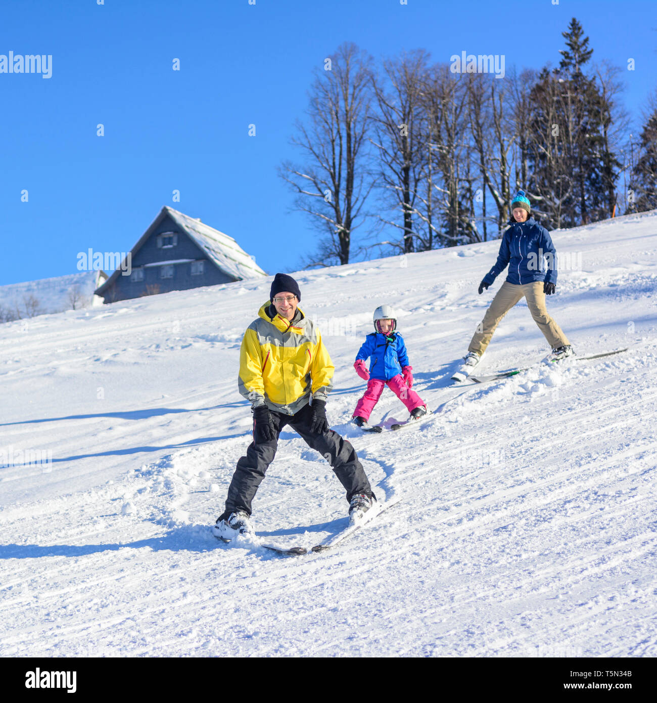 Skiing with the kids on sunny winter day Stock Photo