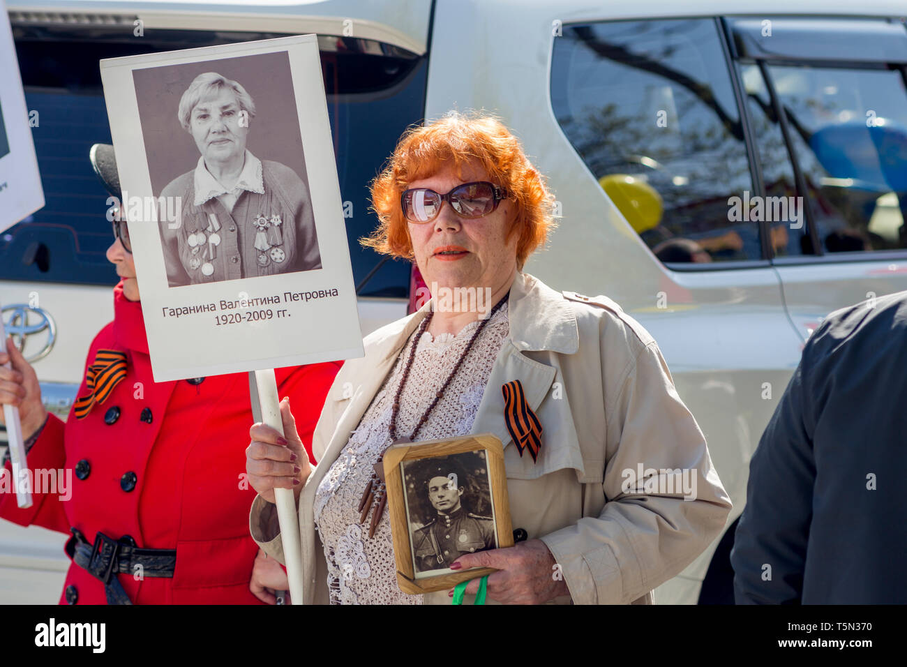 Russia, Nakhodka, 05/09/2017. Old woman holds portrait of her parents, soldiers of Great Patriotic War 1941-1945 between USSR and Nazi Germany. Annual Stock Photo