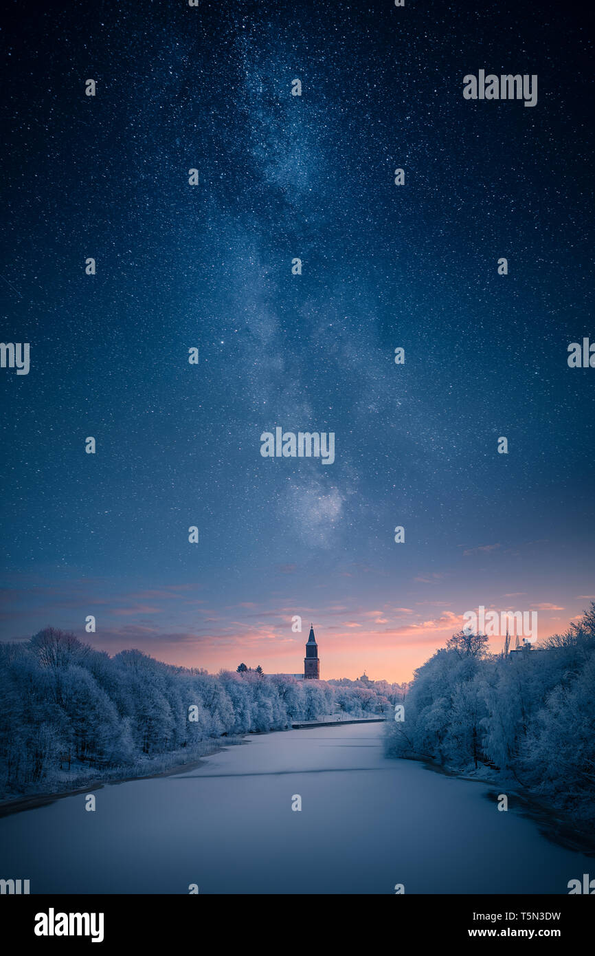 Majestic milky way over a clock tower and icy river at winter Stock Photo