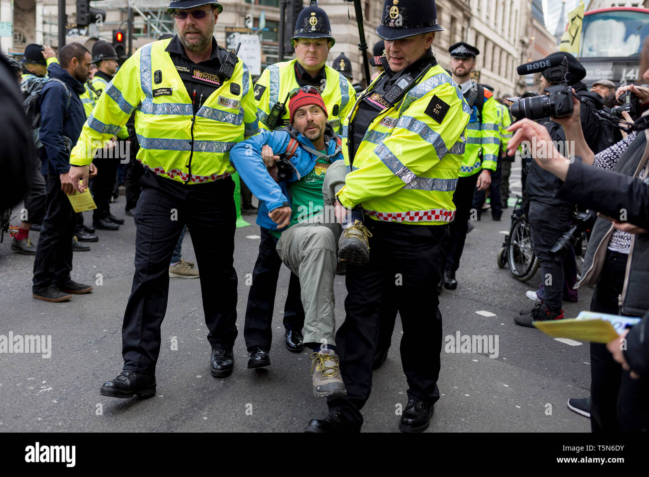An environmental activist is arrested under Section 14 of the Public Order Act after blocking the highway at Bank in the City of London on the 11th and final day of protests, road-blockages and arrests across London by the climate change campaign Extinction Rebellion, on 25th April 2019, in London, England. Stock Photo