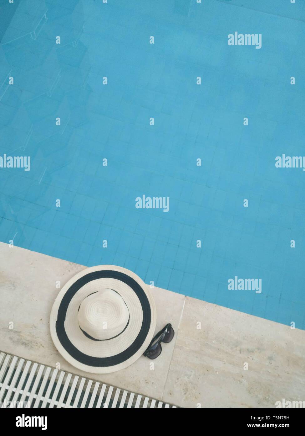 Straw hat with sunglasses near the pool Stock Photo - Alamy
