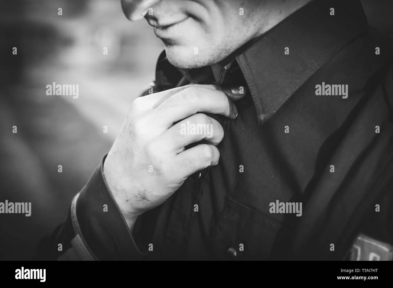 Man corrects his collar shirt. Black and white photo Stock Photo Alamy