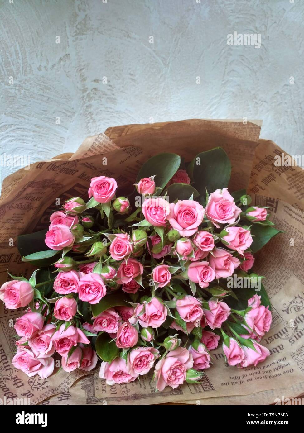 Bouquet of flowers. Pink little bush roses lying on the table. Stock Photo