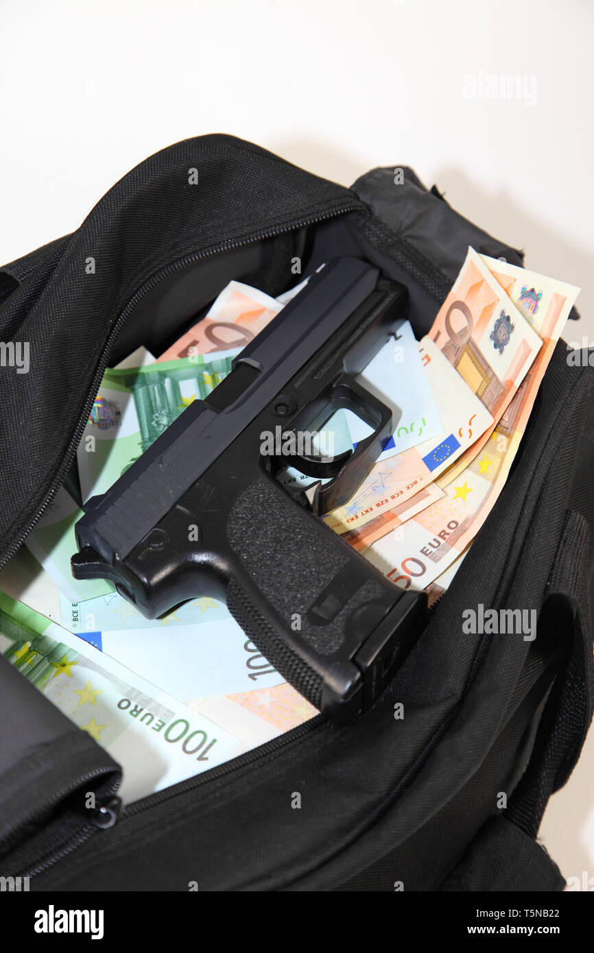 Loot from bank robbery. Sports bag full of money with gun - isolated Stock Photo