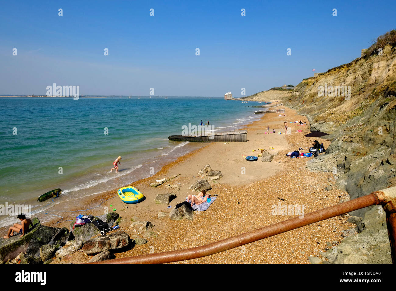 Colwell Bay during the Easter weekend 2019 heatwave and the beach is full of people sunbathing and taking part in all manner of seaside activity. Stock Photo