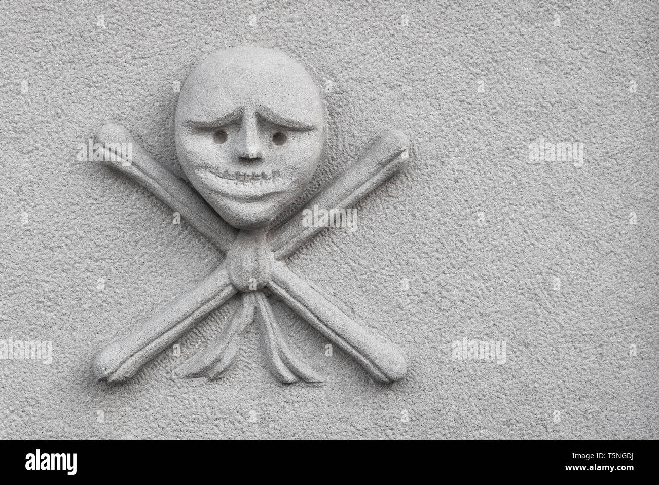 Skull and crossed bones carved on an new stone. Ideal for concepts, events and backgrounds. Space for text. Stock Photo