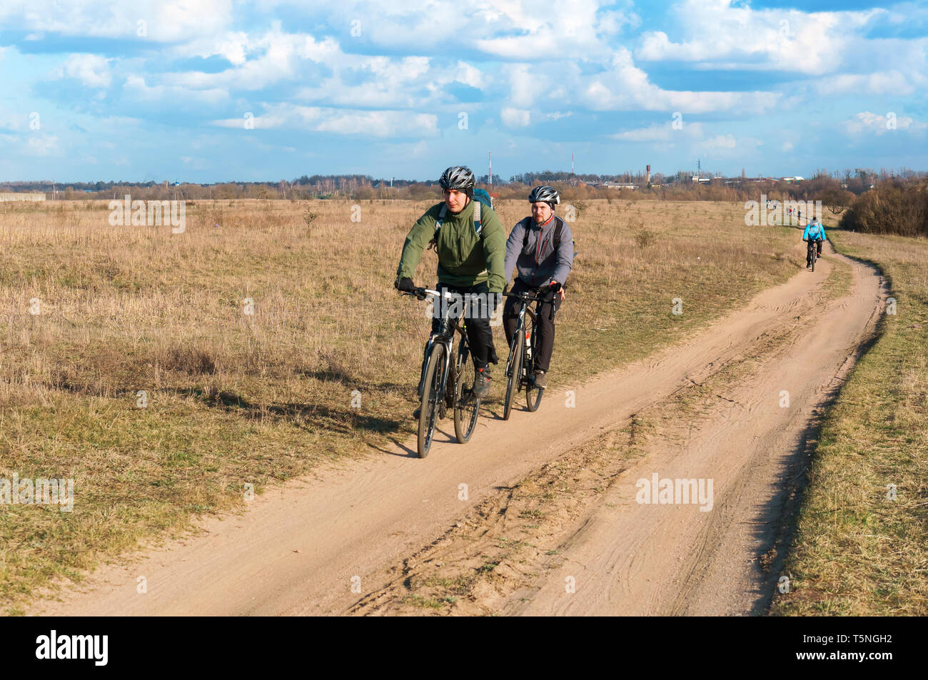 Cycling on the field road, two cyclists, Kaliningrad region, Russia, March 31, 2019 Stock Photo