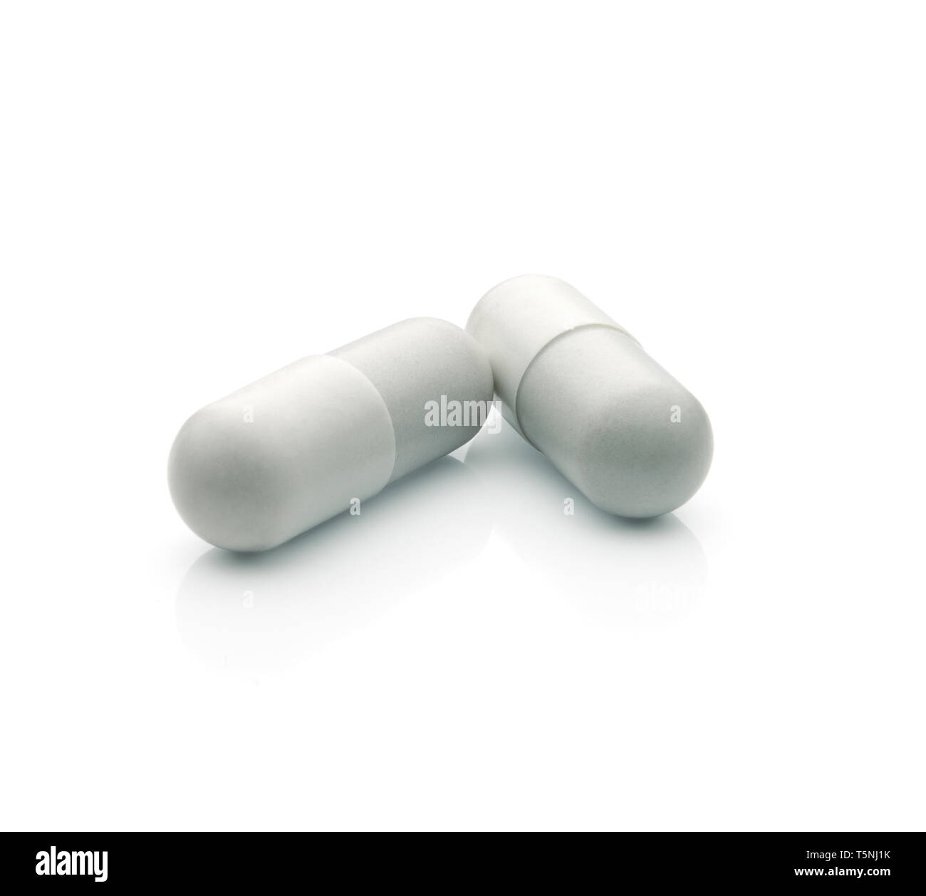 Close up view of two pills against white background. Clipping path Stock Photo