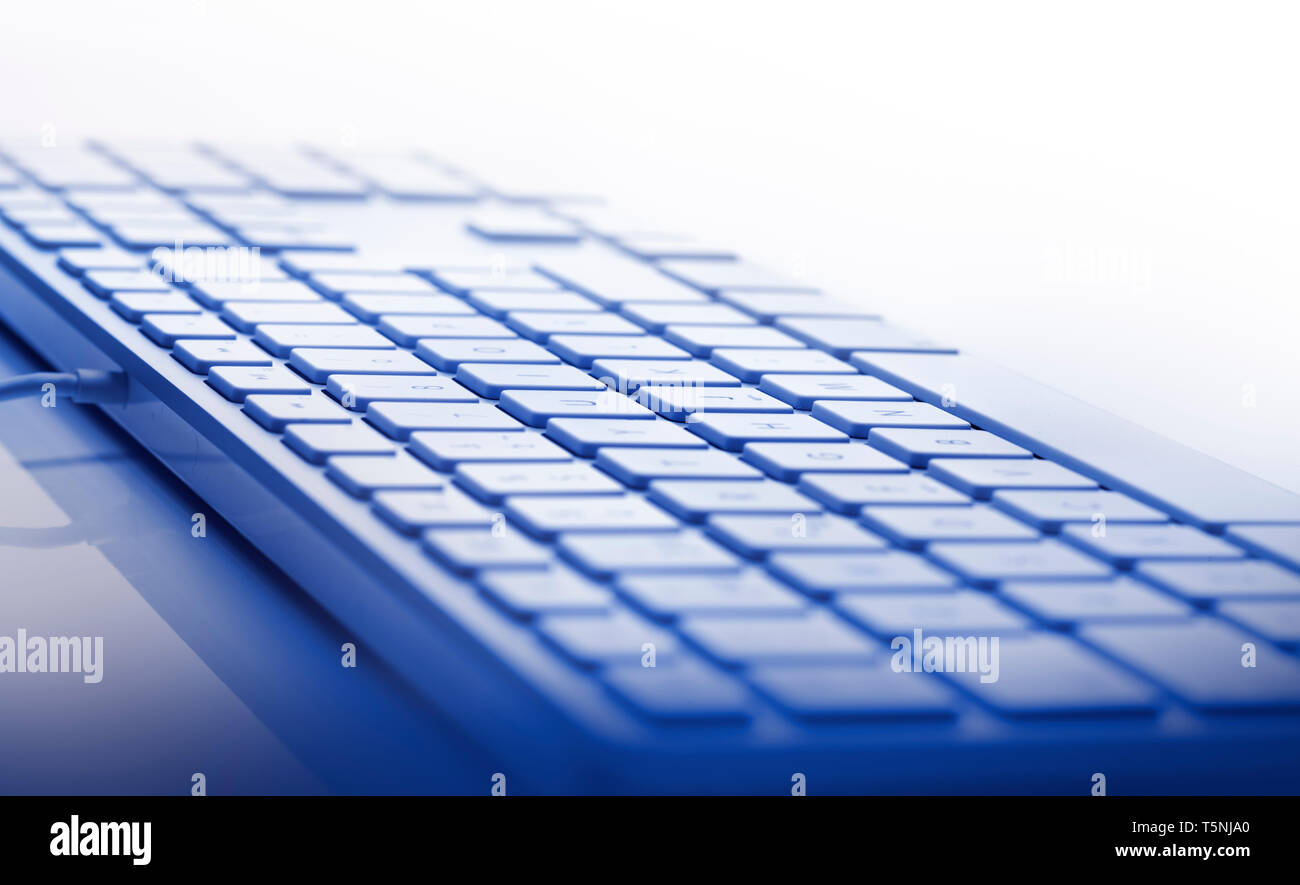 Shallow depth of focus on keyboard against white background. Focus on center of keypath. Blue tone Stock Photo