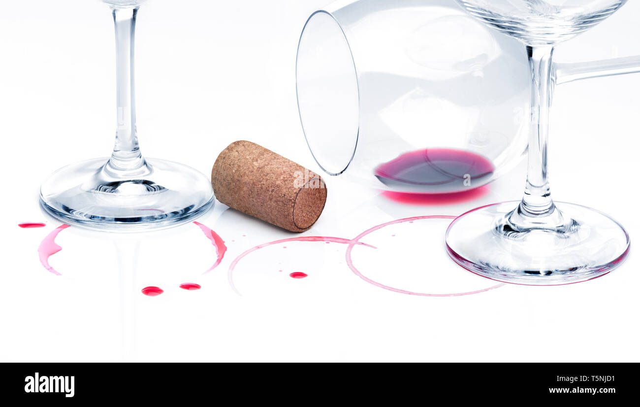 Rest of red wine on a table and empty glasses against white background. End of party concept Stock Photo