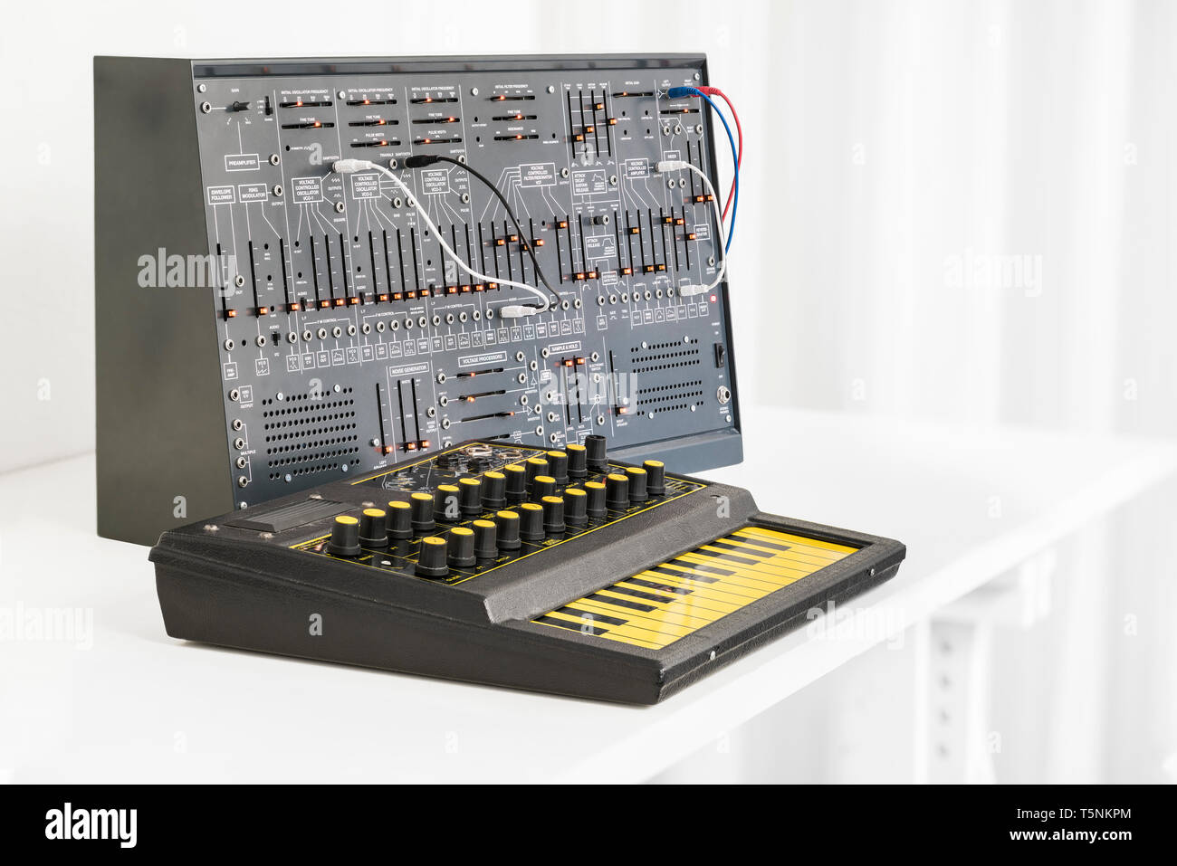 Two Synthesizers. EDP Wasp from 1978 and a modern clone of the Arp 2600 from 1971 with patch cables, in an analog music recording studio. Stock Photo