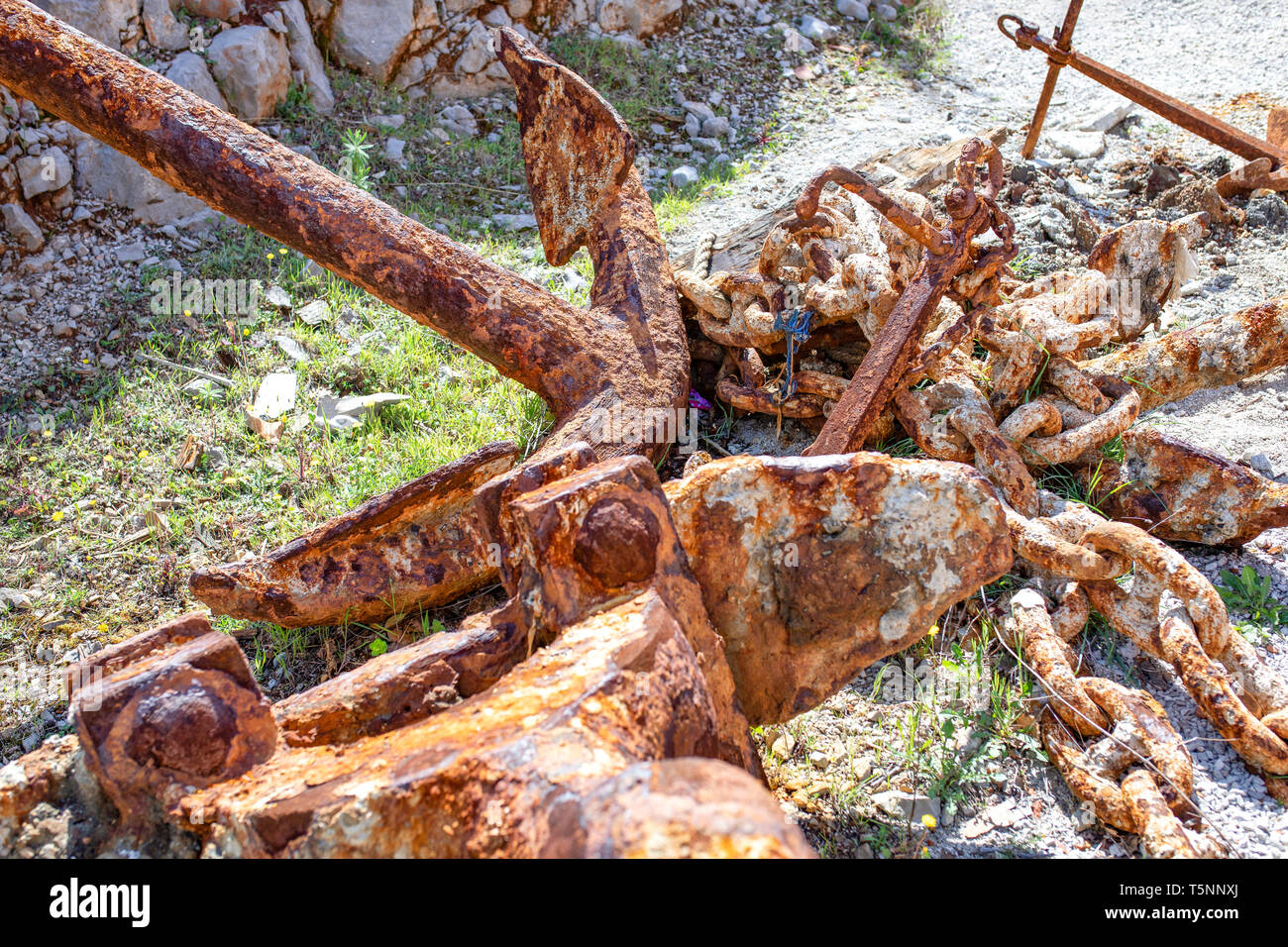 Rusty anchors and the anchor chain links in a harbor. Greece Stock