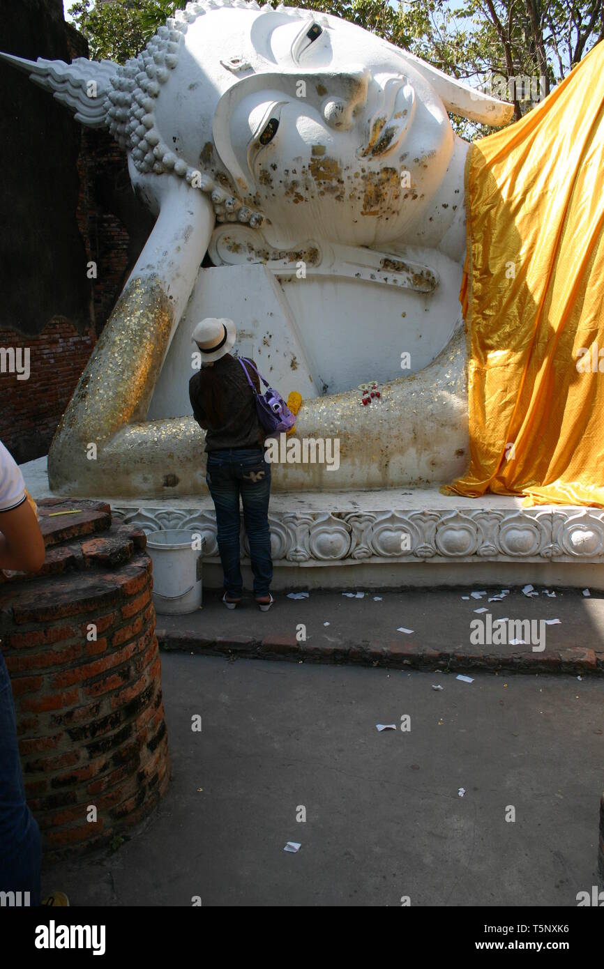 thai lady prays in front of big lying buddha Stock Photo