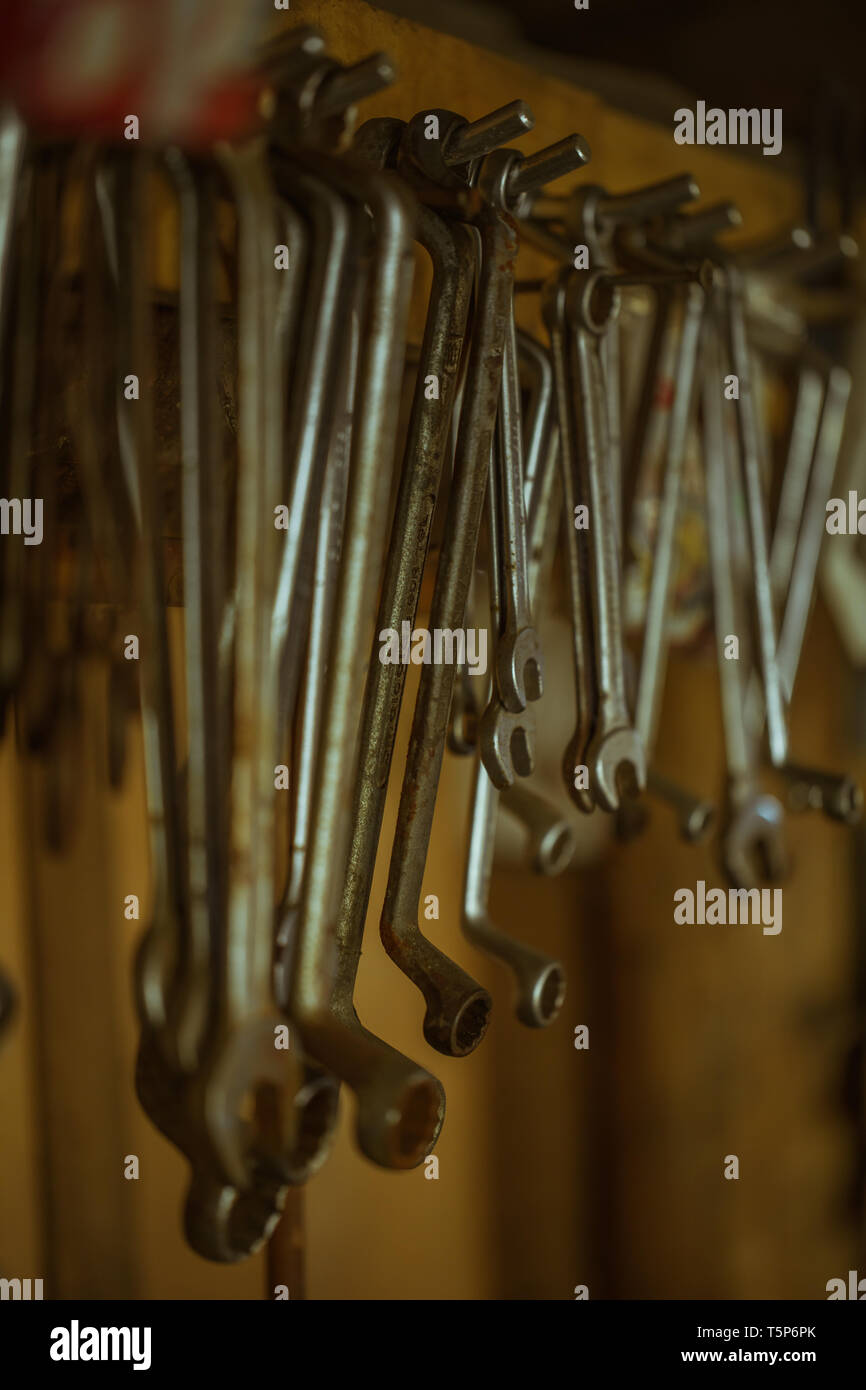 different organized metal spanner tools in a garage, close up Stock