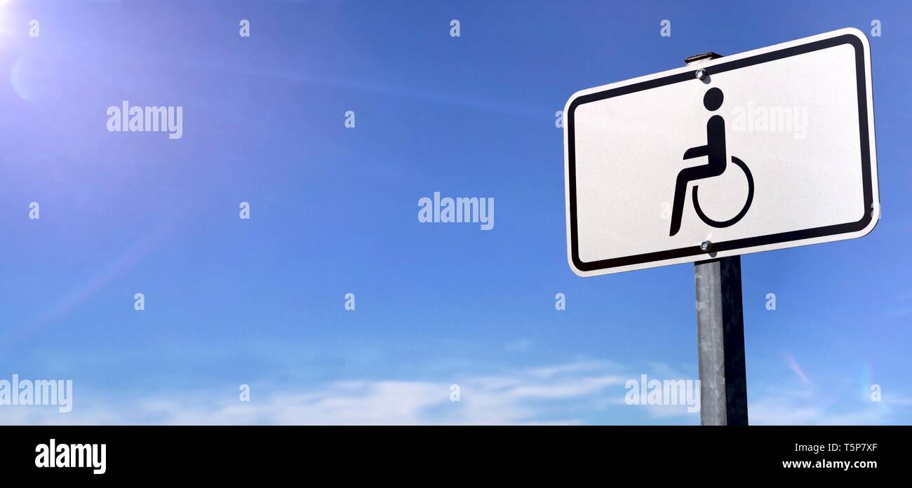 Handicap parking Sign in front of a blue sky. Panoramic image with copy space. Stock Photo