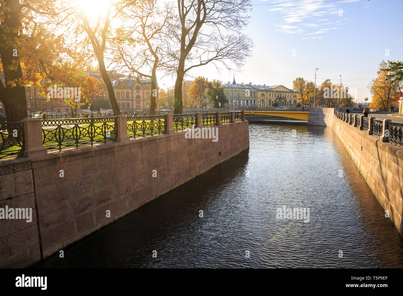 ST. PETERSBURG, RUSSIA - OCTOBER 16, 2018:  Sunny autumn day in St. Petersburg. People relax in the park of New Holland and stroll along the embankmen Stock Photo