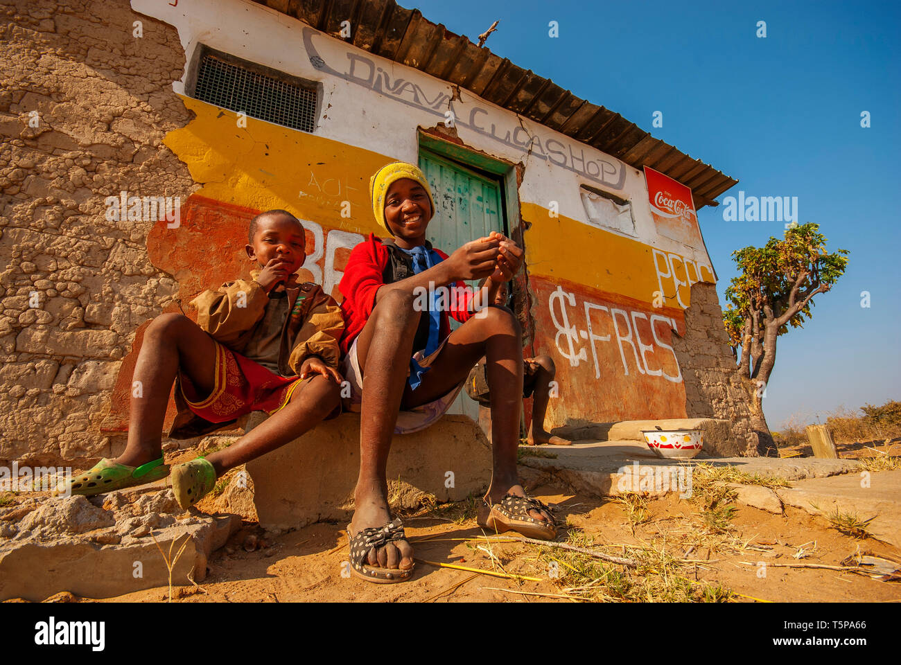 Young africans in front of an descrepit shop just by te road, Caprivi Strip, Namibia Stock Photo