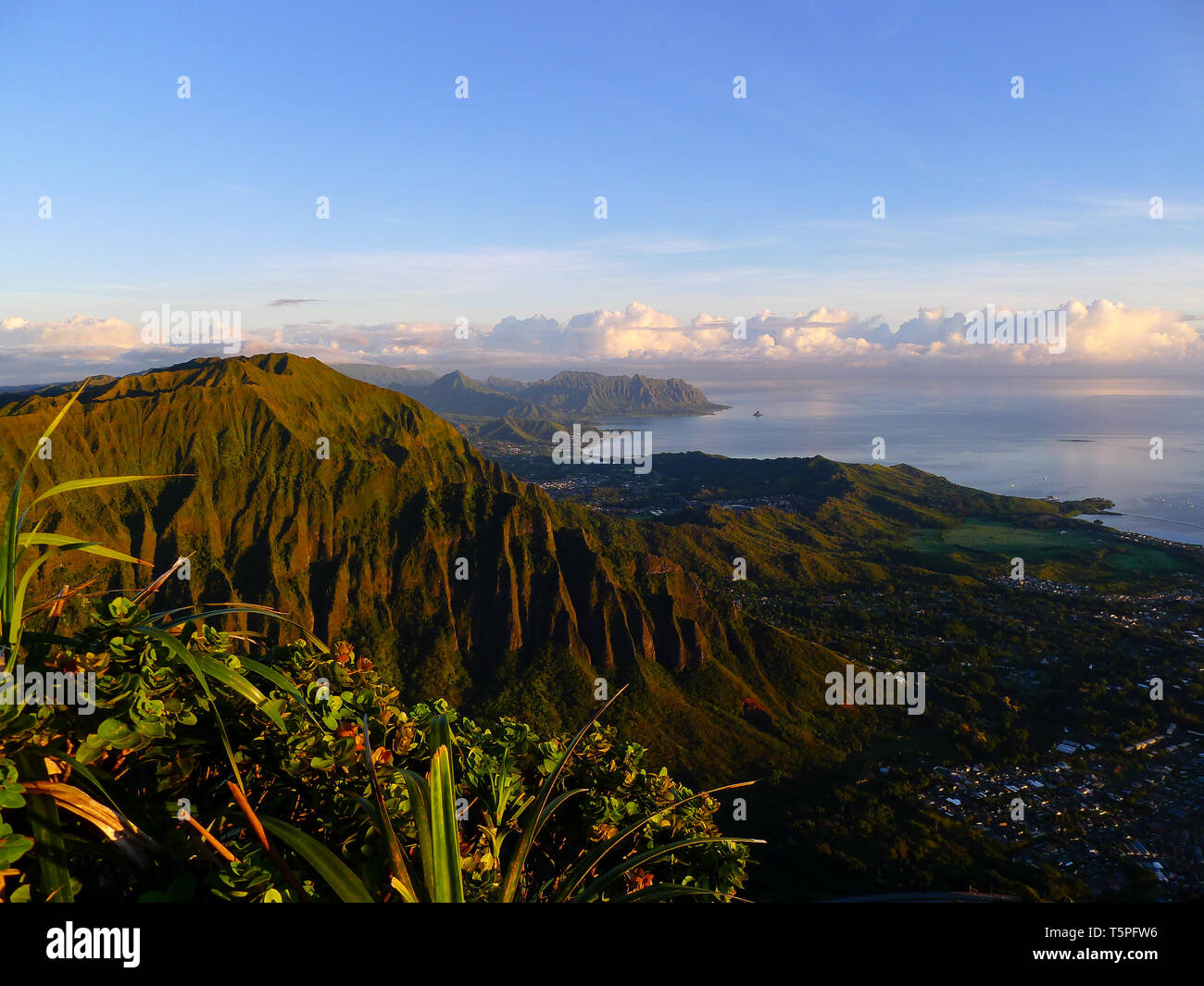 High view on Kaneohe and the mountains of Oahu with a rising sun from behind Stock Photo