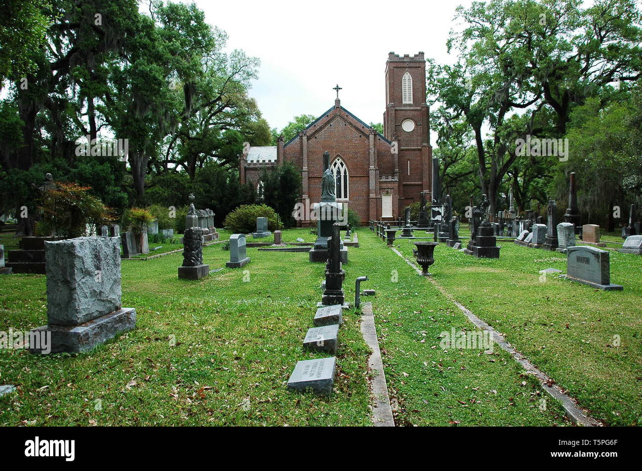 St. Francisville, Louisiana, USA - 2019: Tombs and oak trees at a graveyard located at the historic Grace Episcopal Church. Stock Photo