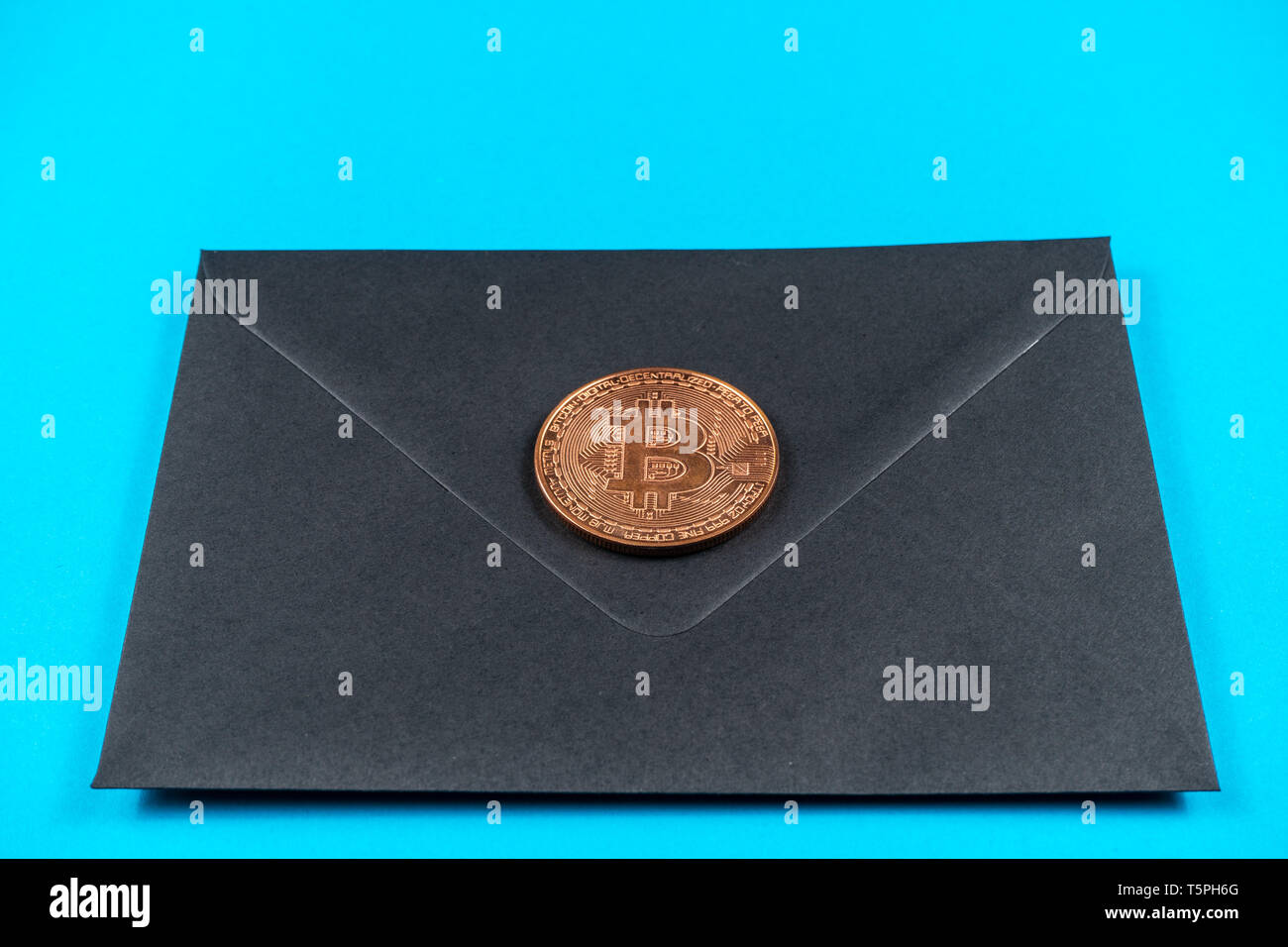 Black closed envelope on light blue background. Stock Photo