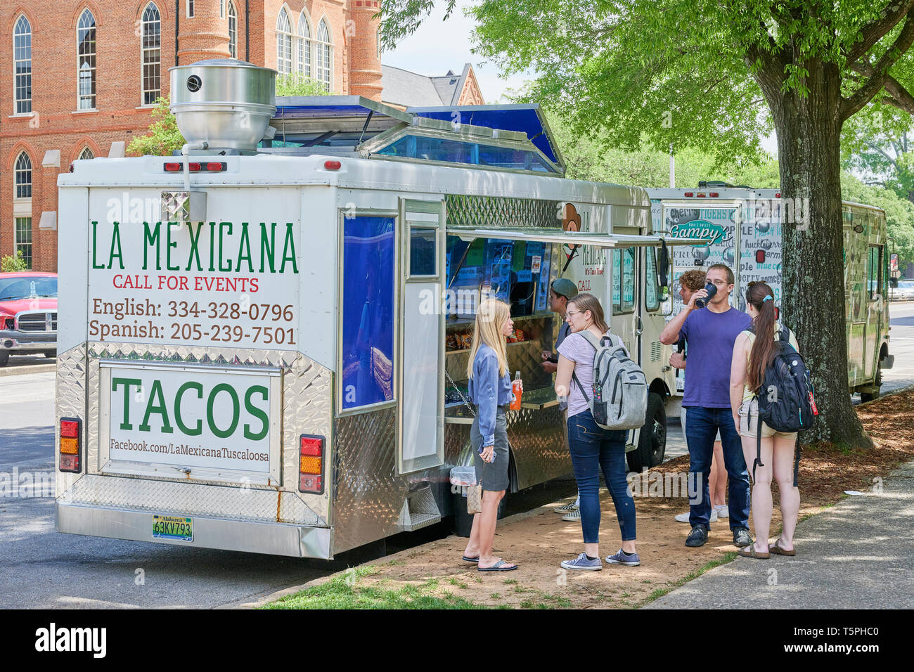 Students gather or in line at a Taco truck or food truck on the campus of the University of Alabama at lunch time in Tuscaloosa Alabama, USA. Stock Photo