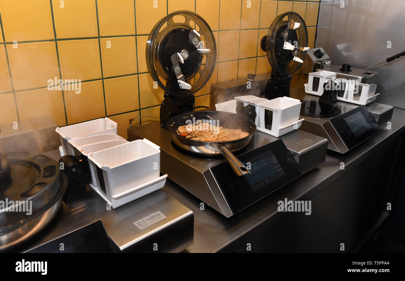 Duesseldorf, Germany. 26th Apr, 2019. Cooking robots are standing in the  China snack bar "Ai Wok". Those who eat here do not see a cook, because  here four robots cook for the