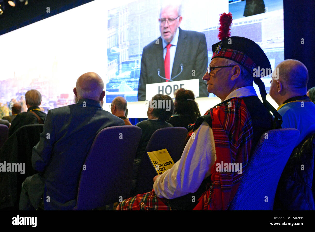Edinburgh, Scotland, United Kingdom. 27th Apr, 2019. A delegate in Highland dress listens to the opening address at the Scottish National Party's Spring Conference in the Edinburgh International Conference Centre. Credit: Ken Jack/Alamy Live News Stock Photo