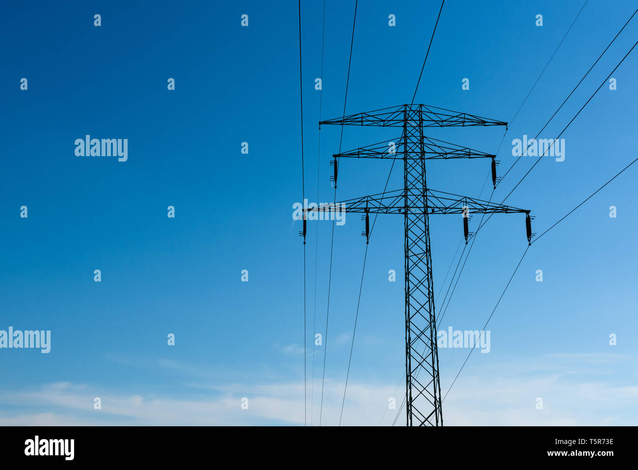 High voltage power lines on pylon at sunny day with blue sky as copy ...