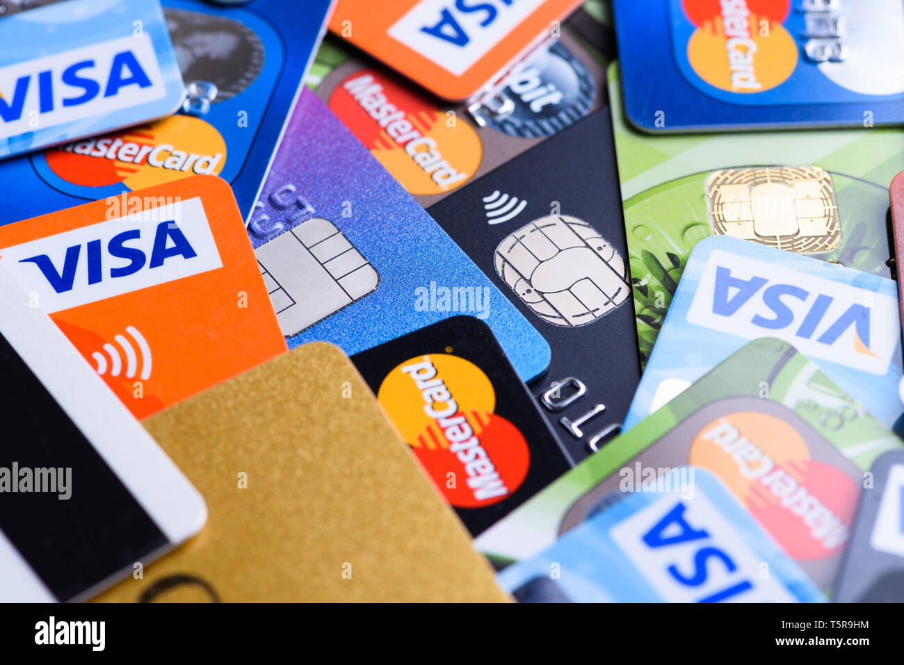 Krakow, Poland - June 16, 2017: Pile of plastic bank payment cards, Visa and Mastercard, credit and debit with different chips and wireless payment te Stock Photo