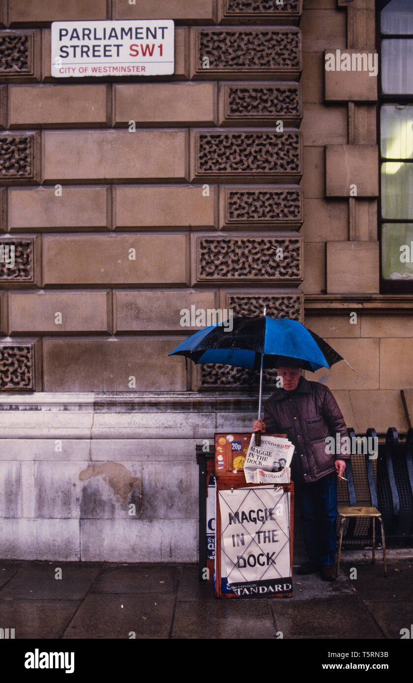 London England UK. Newspaper vendor in Westminster near Downing Street with negative headlines about the Prime Minister Margaret Thatcher in 1985 Stock Photo