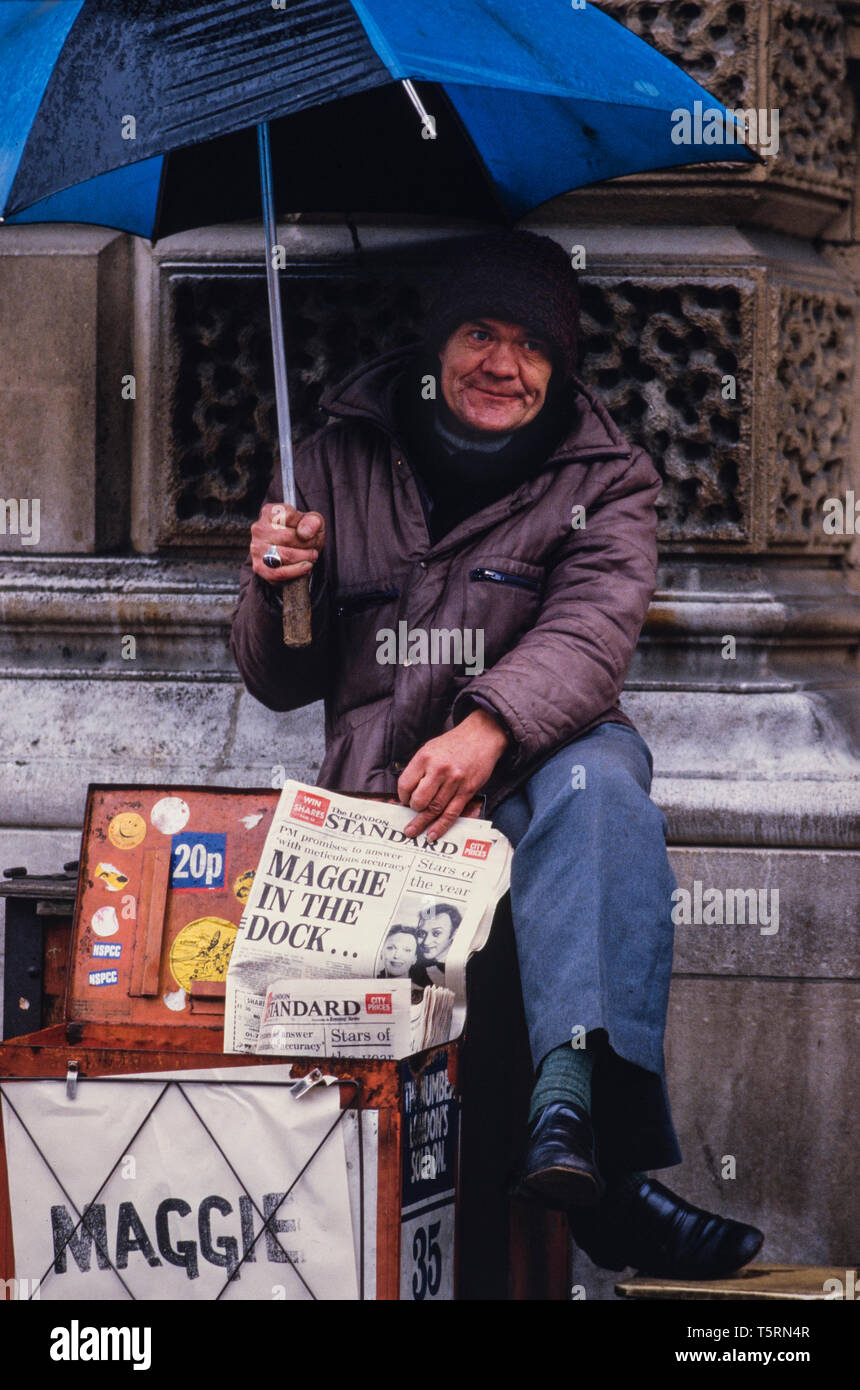 London England UK. Newspaper vendor in Westminster near Downing Street with negative headlines about the Prime Minister Margaret Thatcher in 1985 Stock Photo