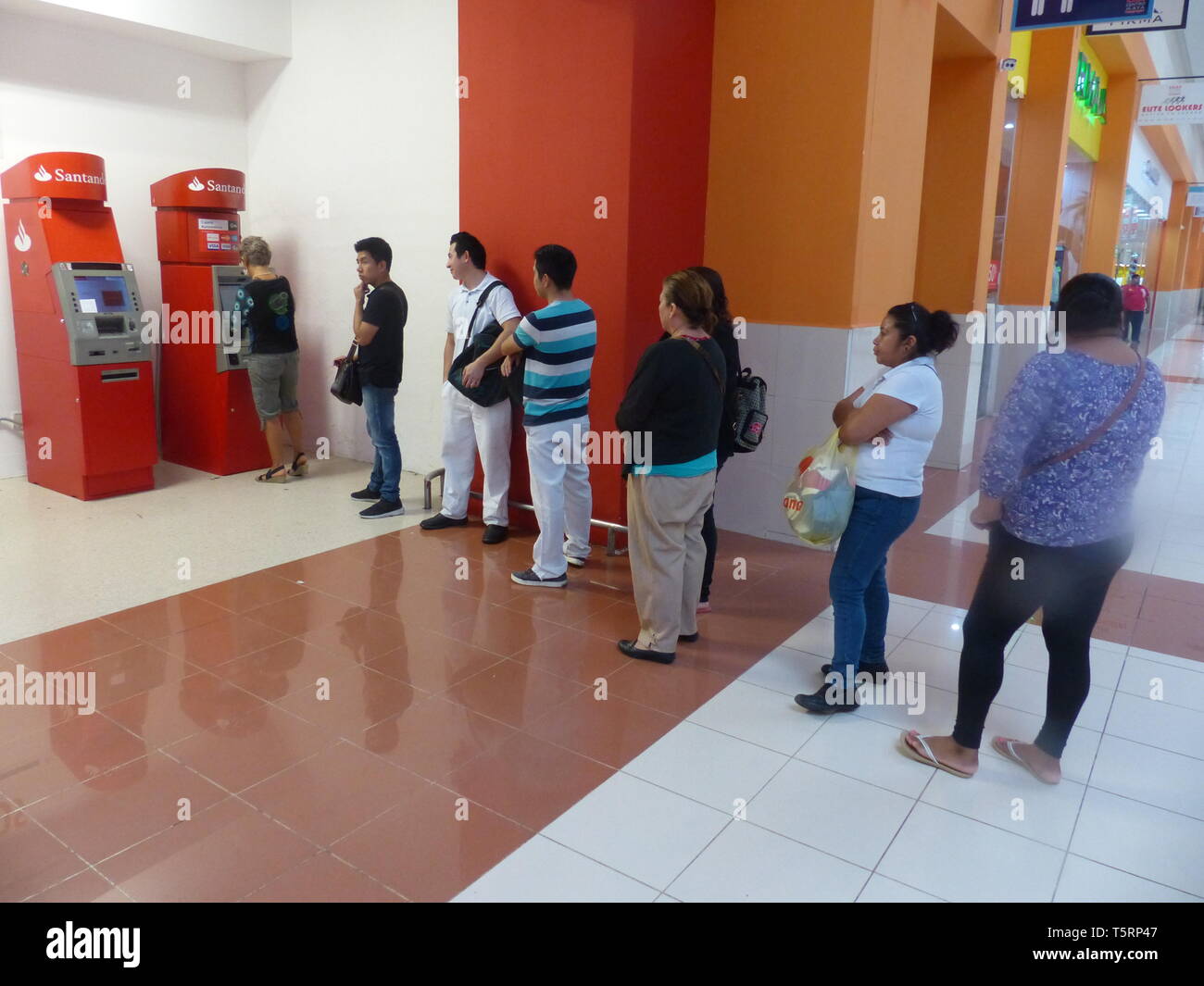 Customers line up to withdraw cash from ATM machine Stock Photo - Alamy