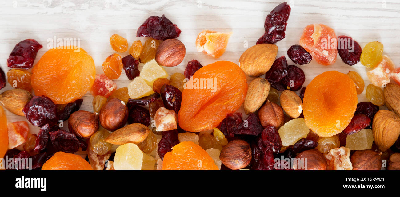 Dried fruits and nut mix on white wooden background, top view. Overhead