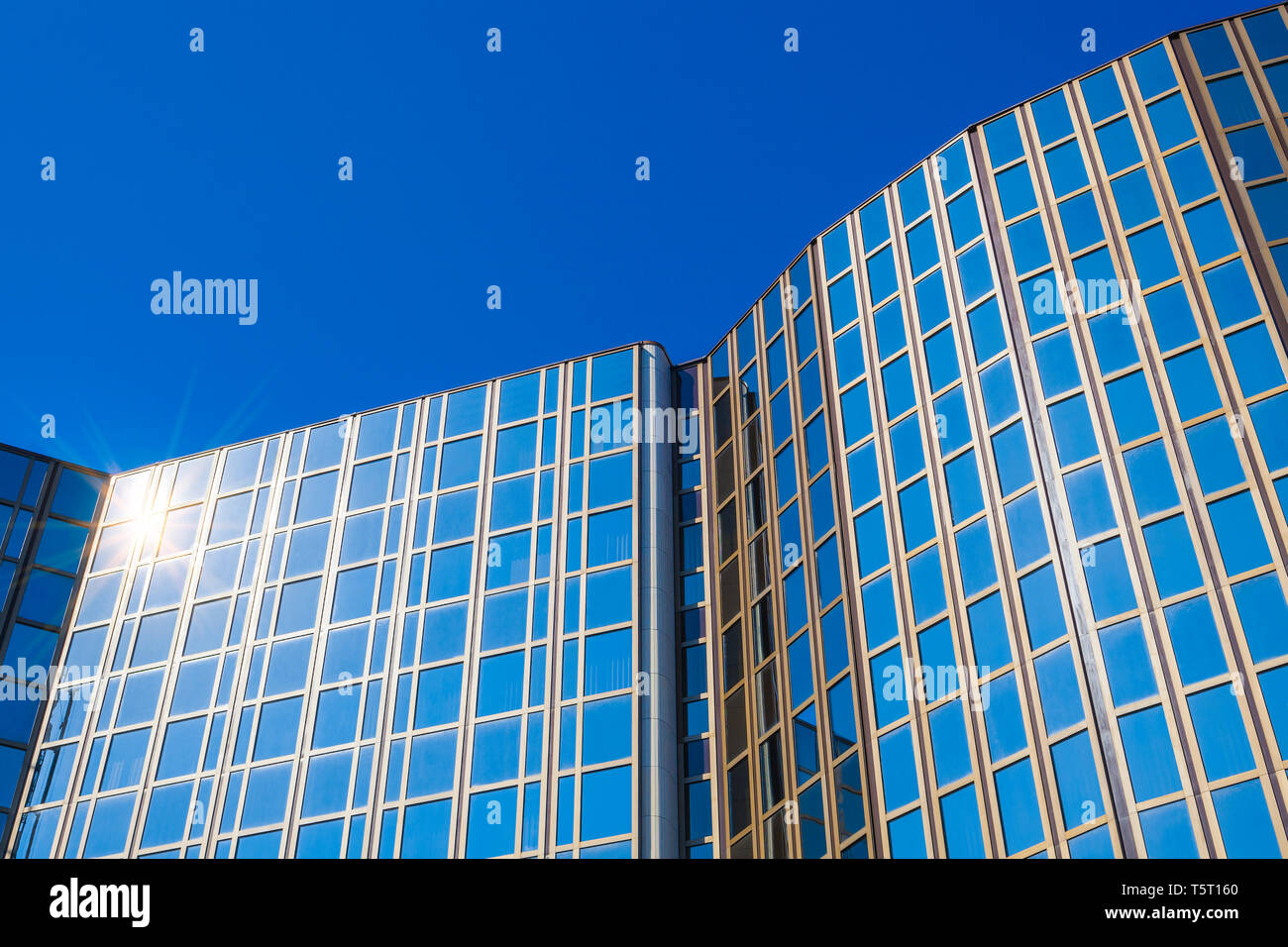 Modern office building with glass facade in front of blue sky Stock ...