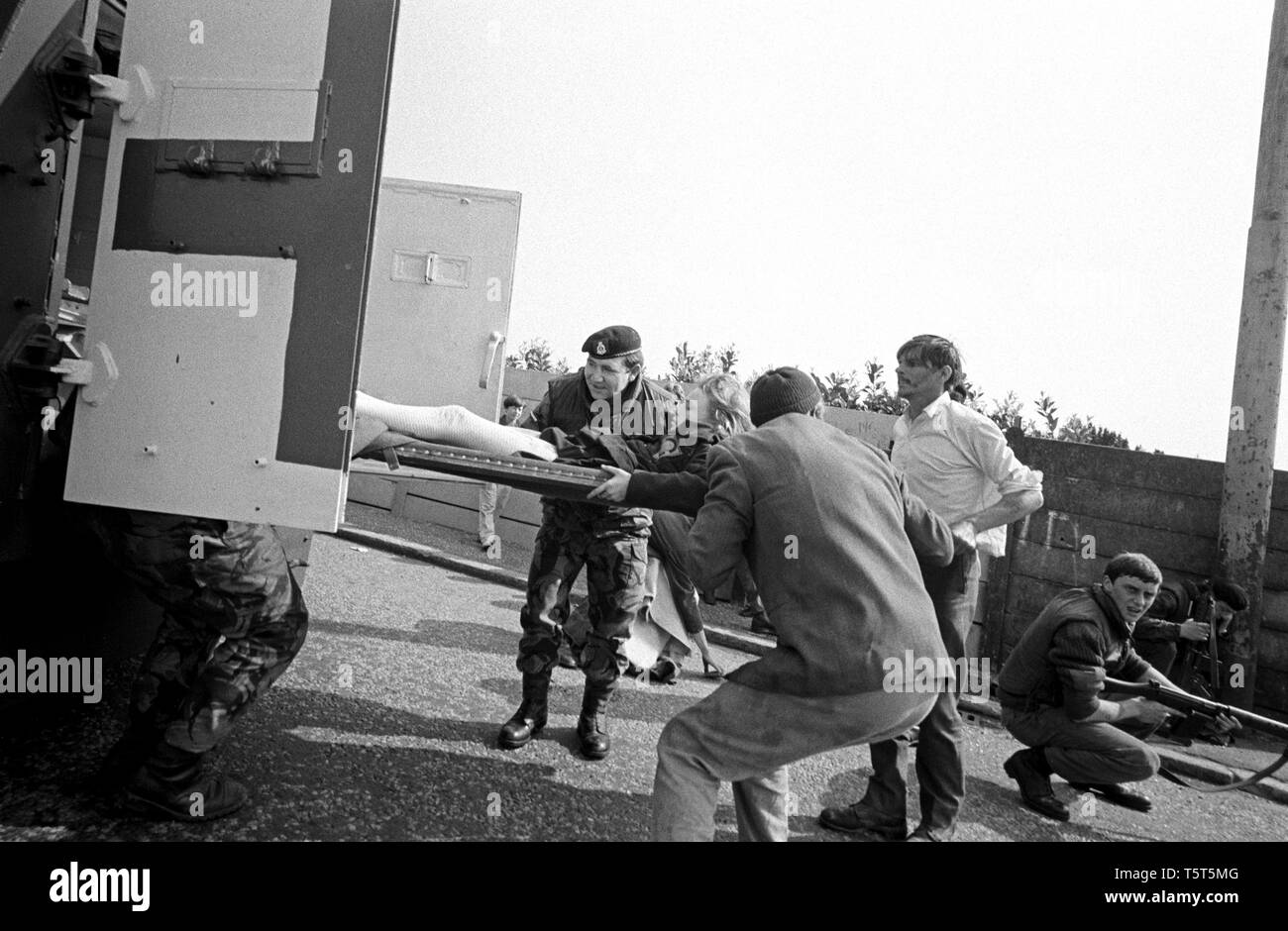 A young girl who was shot in a IRA sniper attack being put into a British Army ambulance, Ballymurphy, West Belfast, Northern Ireland in the early 70s during The Troubles Stock Photo
