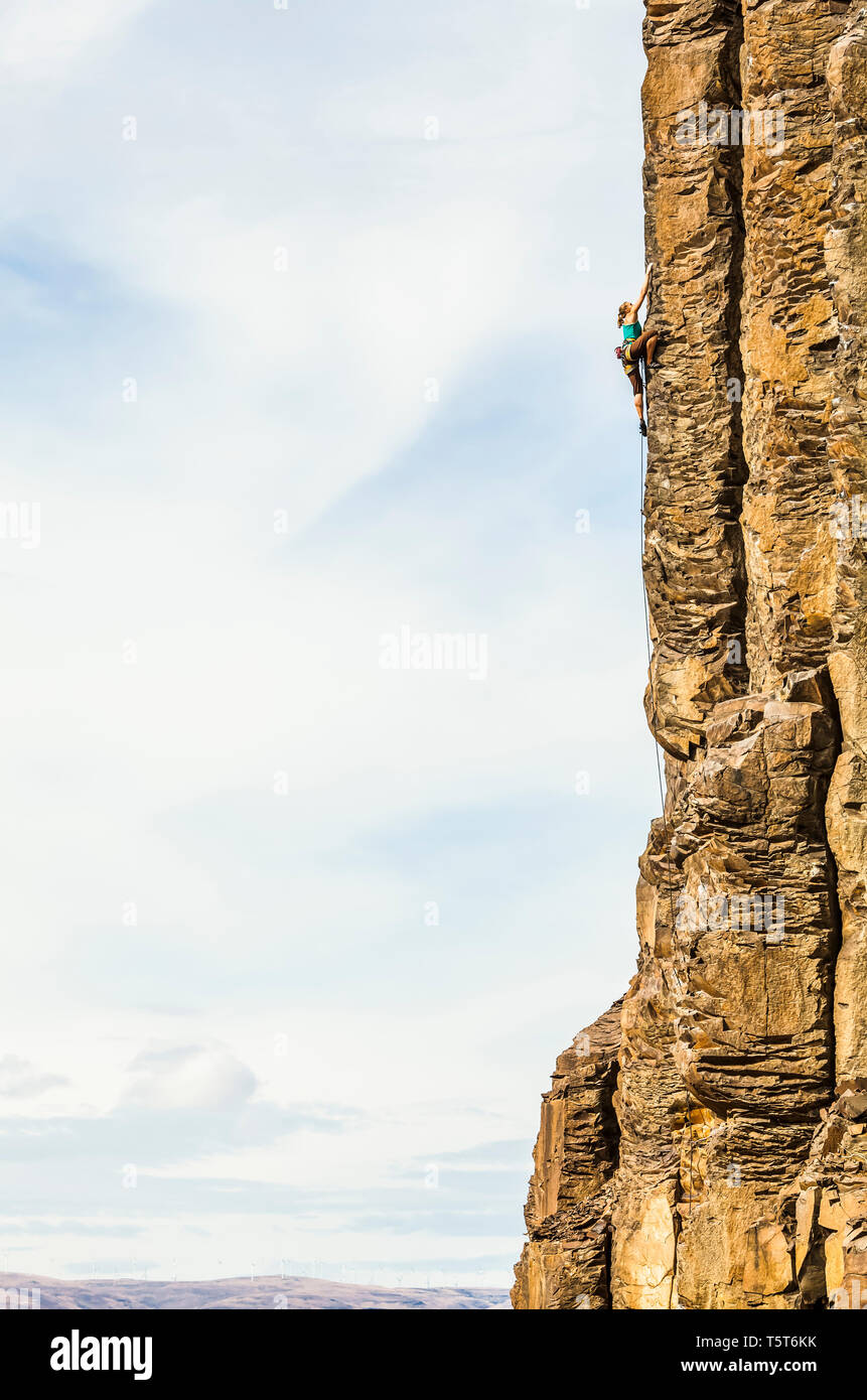 A woman climbing a basalt rock cliff in central Washington State, USA. Stock Photo