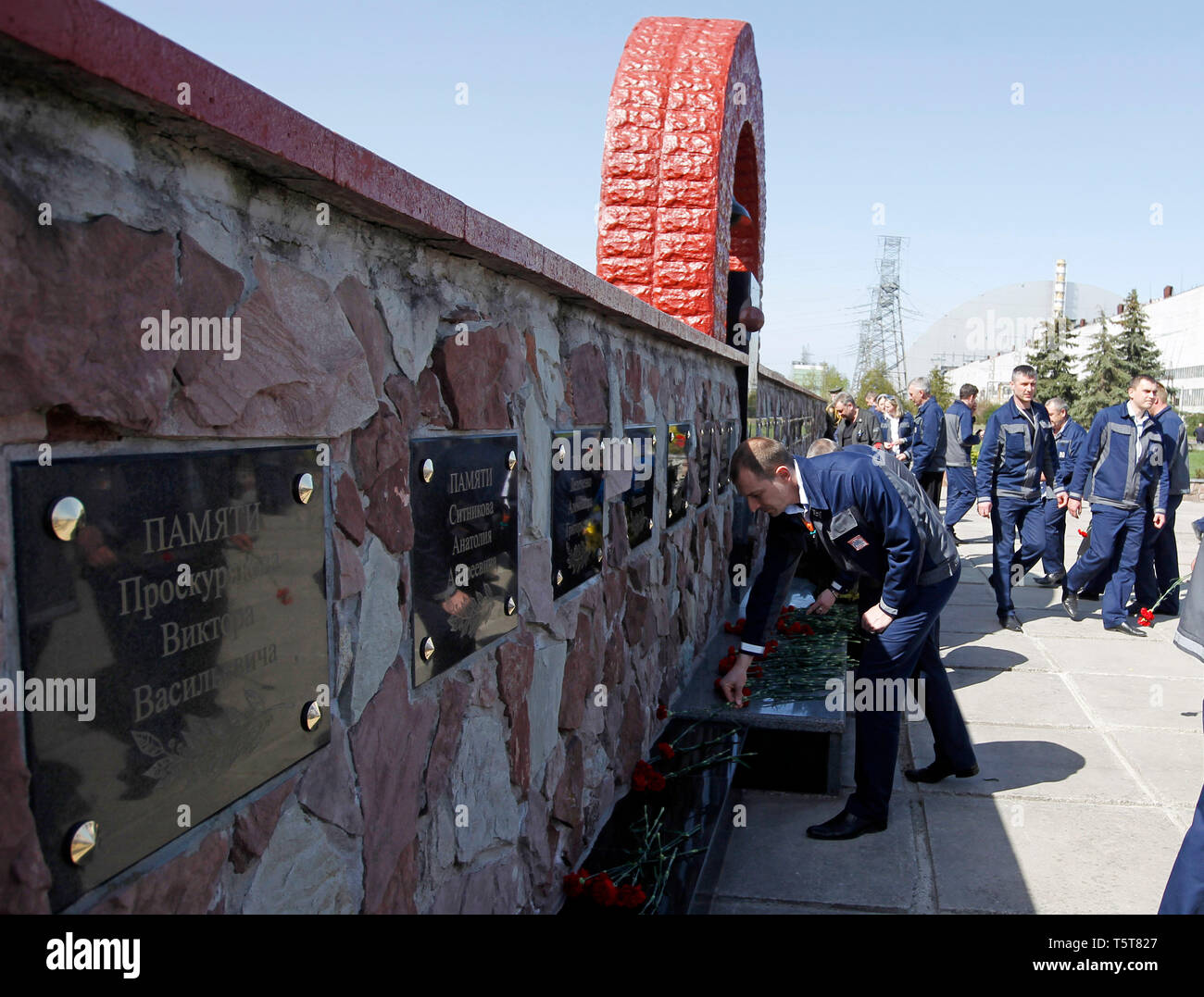 Workers are seen laying flowers to a monument of 'liquidators' during the anniversary. Ukrainians marked the 33rd anniversary of Chernobyl catastrophe. The explosion of the fourth block of the Chernobyl nuclear plant on 26 April 1986 is still regarded as the biggest accident in the history of nuclear power generation. Stock Photo