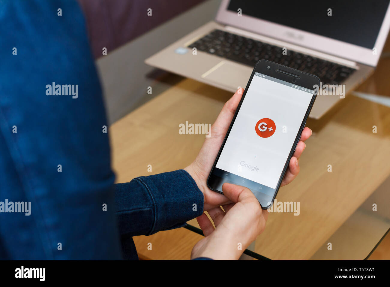 SAN FRANCISCO, US - 22 April 2019: Close up to female hands holding smartphone using Google plus for G Suite application, San Francisco, California Stock Photo