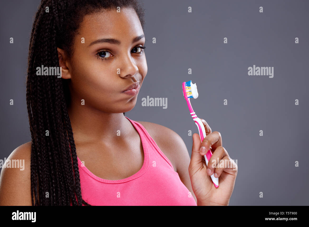 Portrait of a smiling cute woman holding toothbrush Stock Photo. 