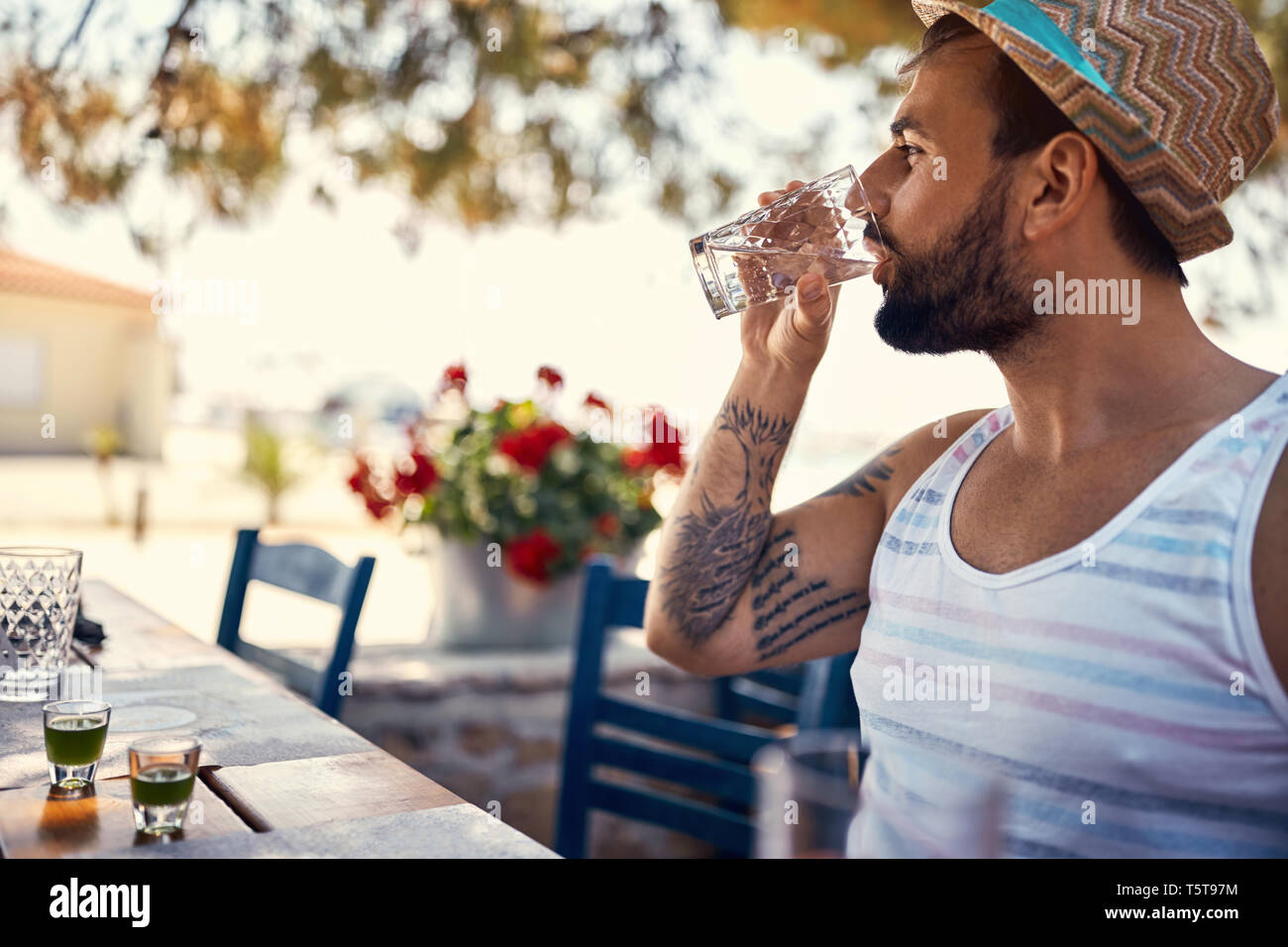 Young man hipster relaxes and drinking on vacation Stock Photo