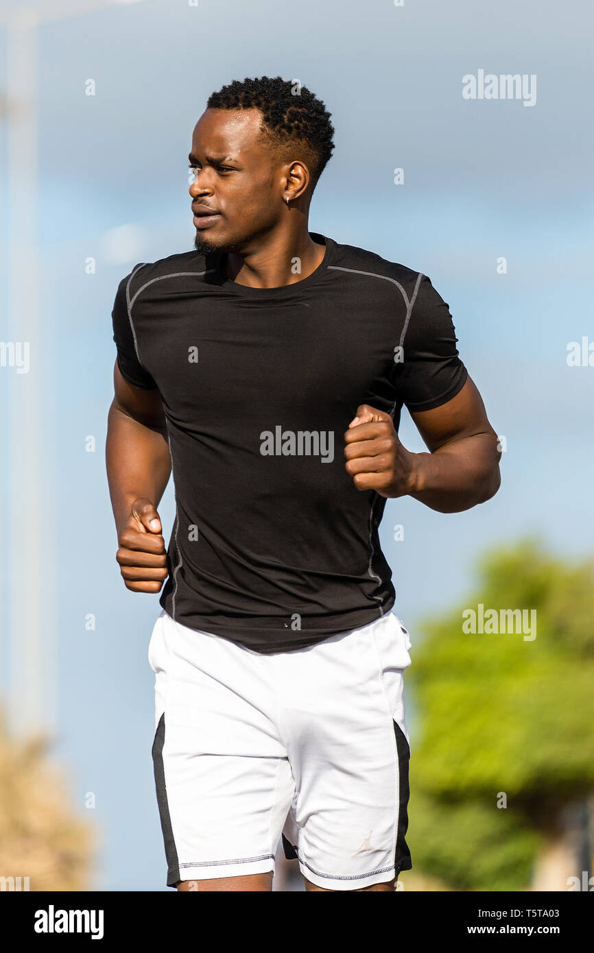 Black african american young man running outdoor Stock Photo - Alamy