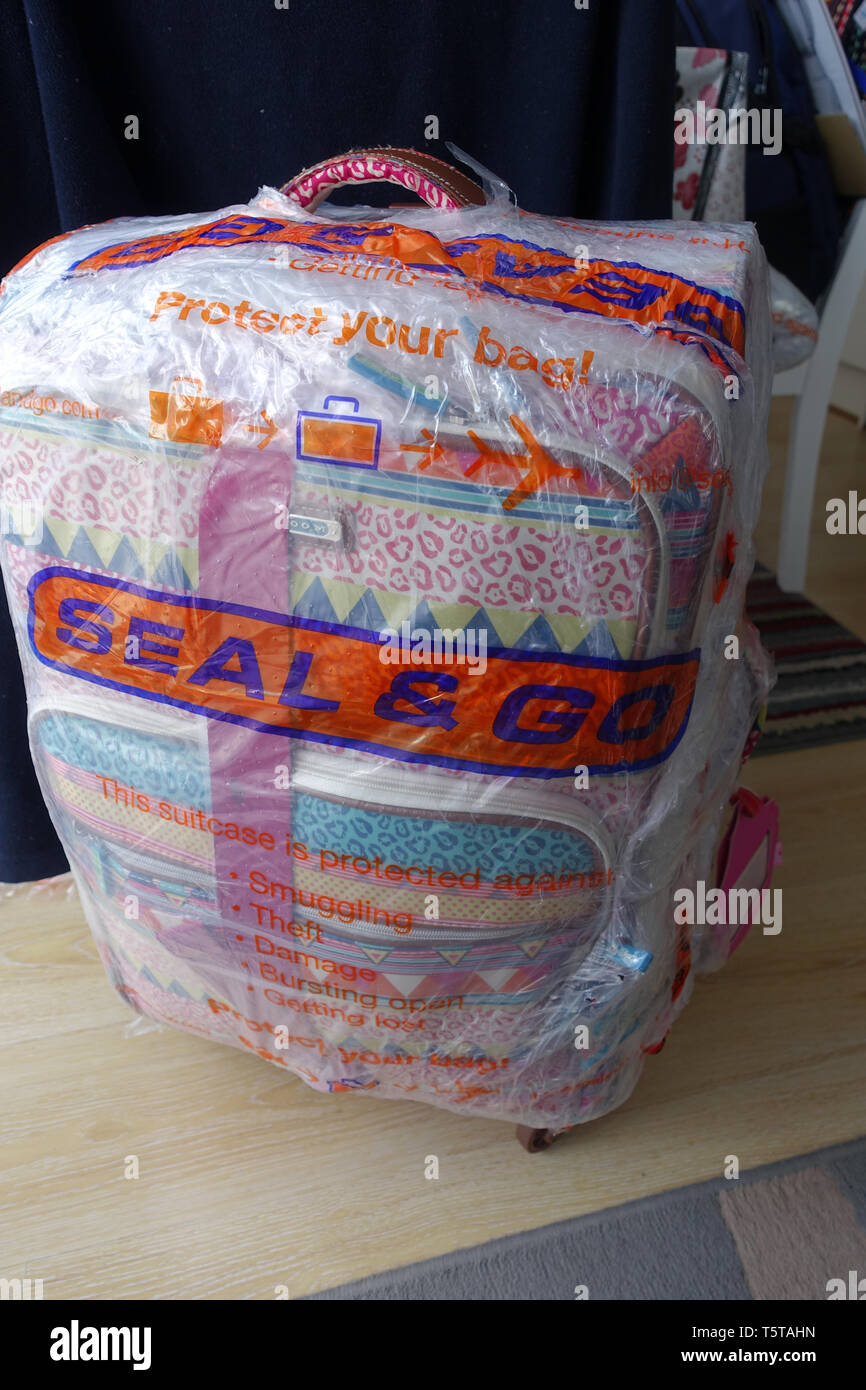 Seal and Go airline luggage wrapping Stock Photo