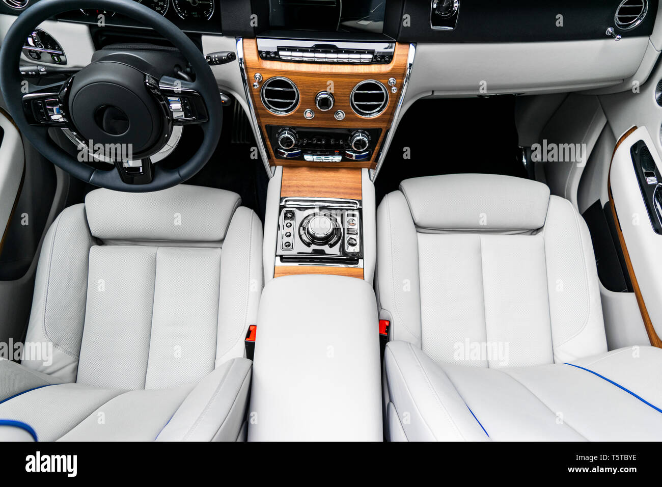 Modern luxury car white leather interior with natural wood panel. Part of leather car seat