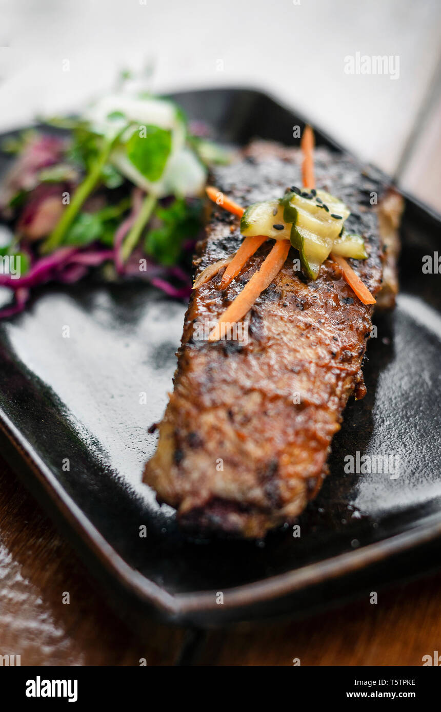 marinated grilled barbecue pork rib with salad and pickled vegetables Stock Photo